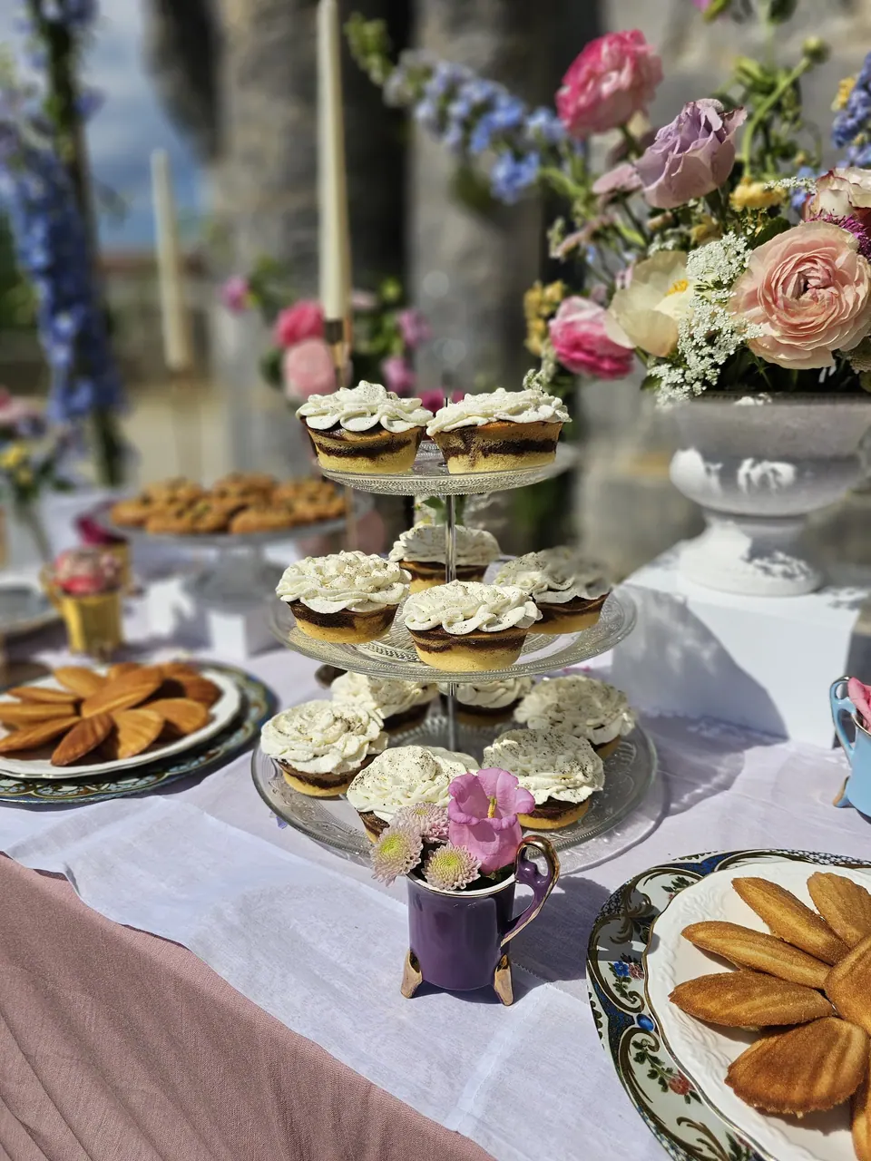 Buffet sucré de mariage avec cupcakes, biscuits et fleurs