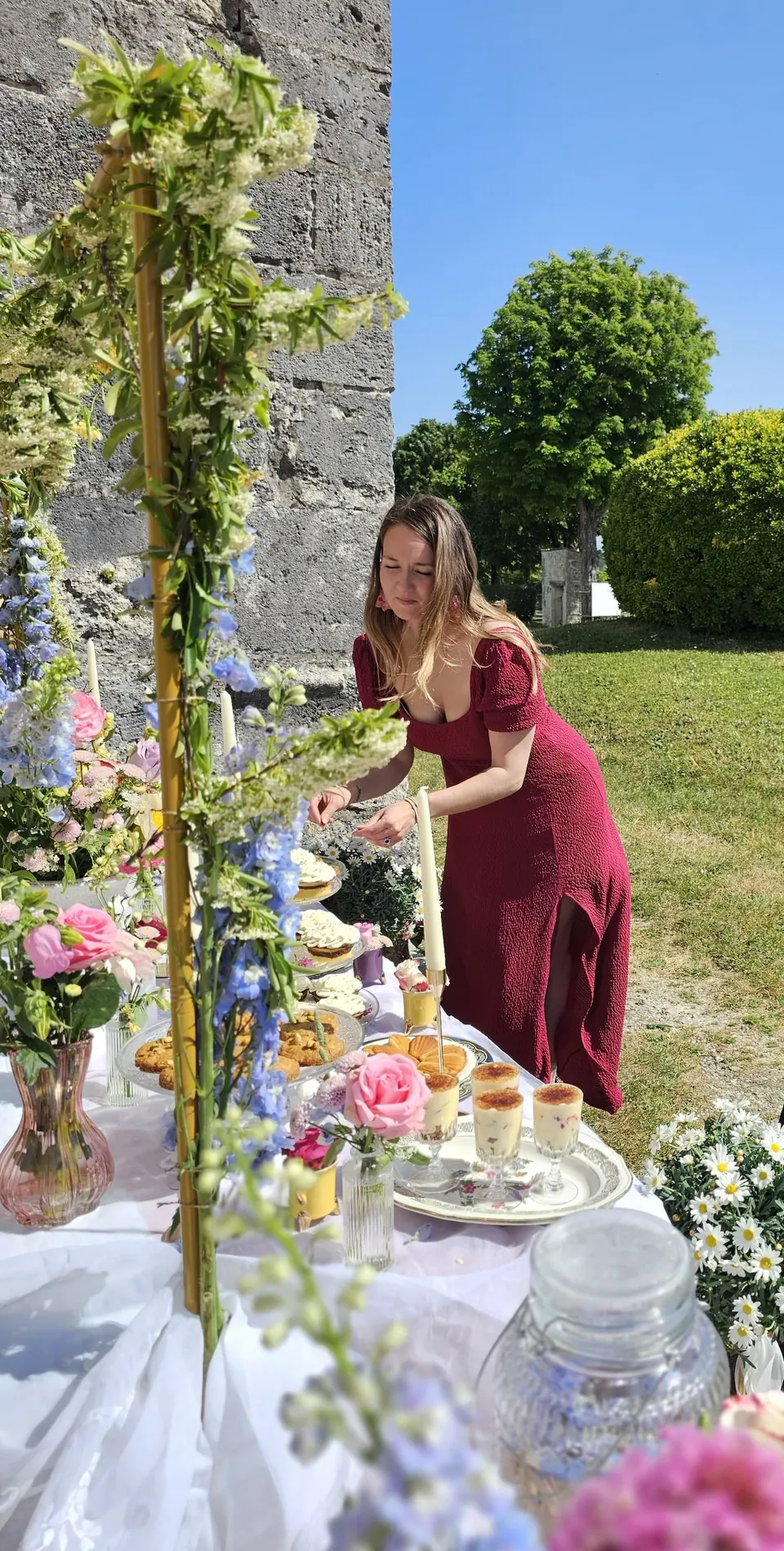 La fondatrice de CAPASSECREEEME dressant un buffet sucré fleuri en extérieur